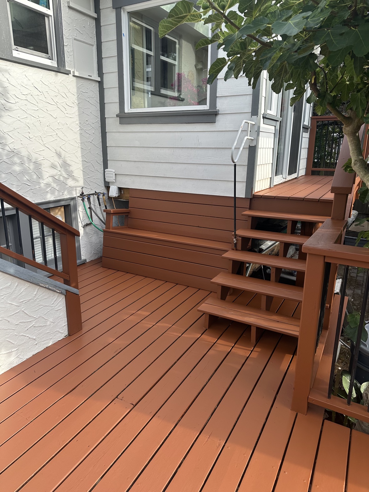 Deck staining project beside a freshly painted house exterior in Victoria, BC