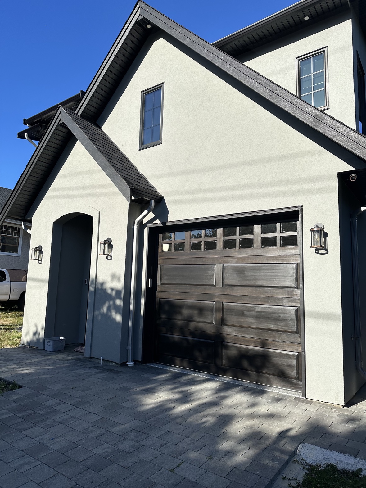 House exterior painting, stucco home with stained garage door in Victoria, BC
