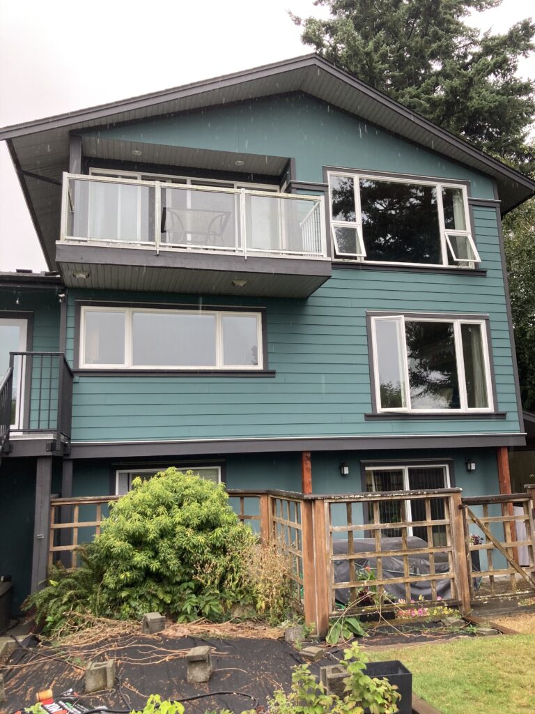 Teal house exterior painting balconies victoria by Rebirth Painting Ltd. in Victoria, BC